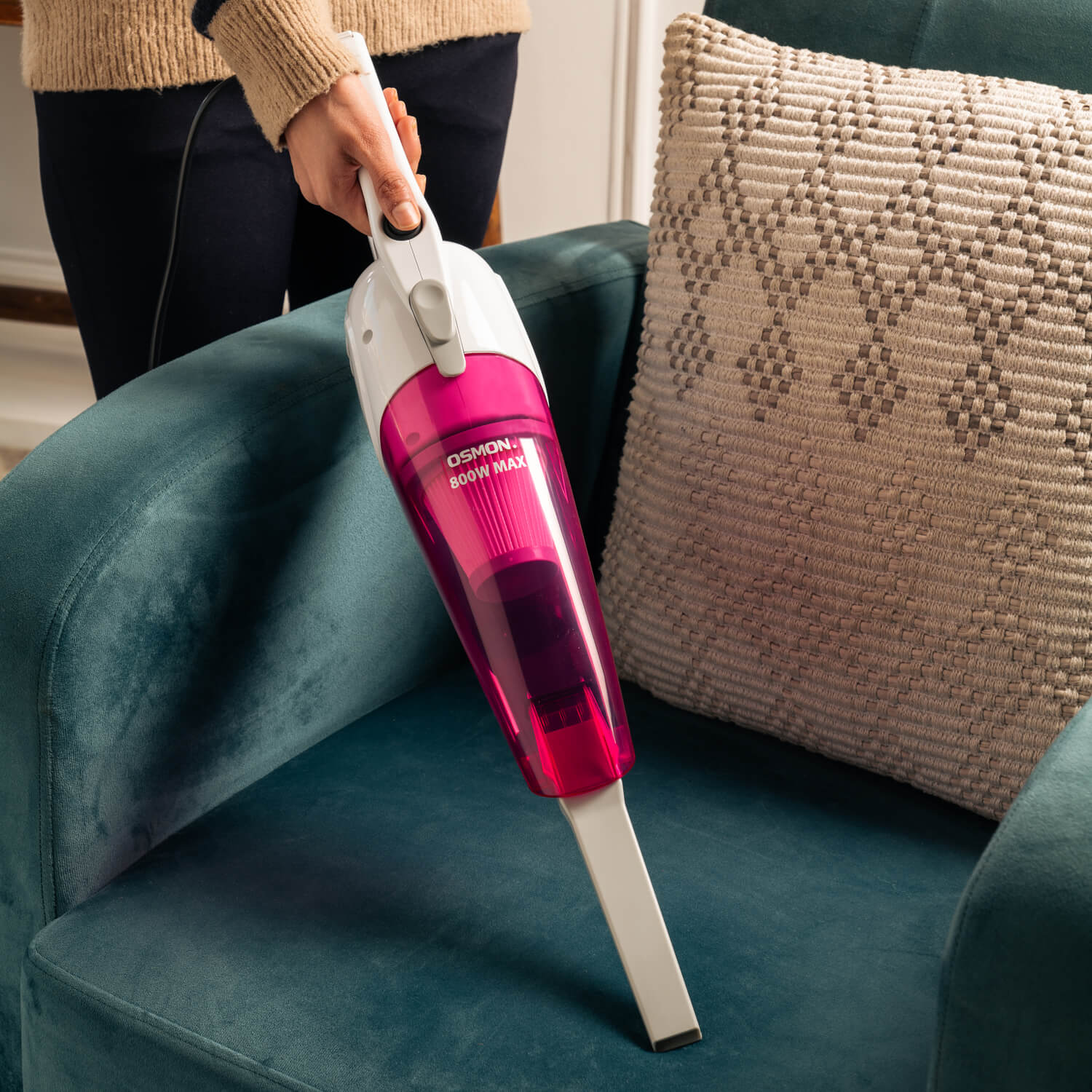 A 2-in-1 upright, handheld, and stick vacuum cleaner showcased in a modern home setting while cleaning a sofa