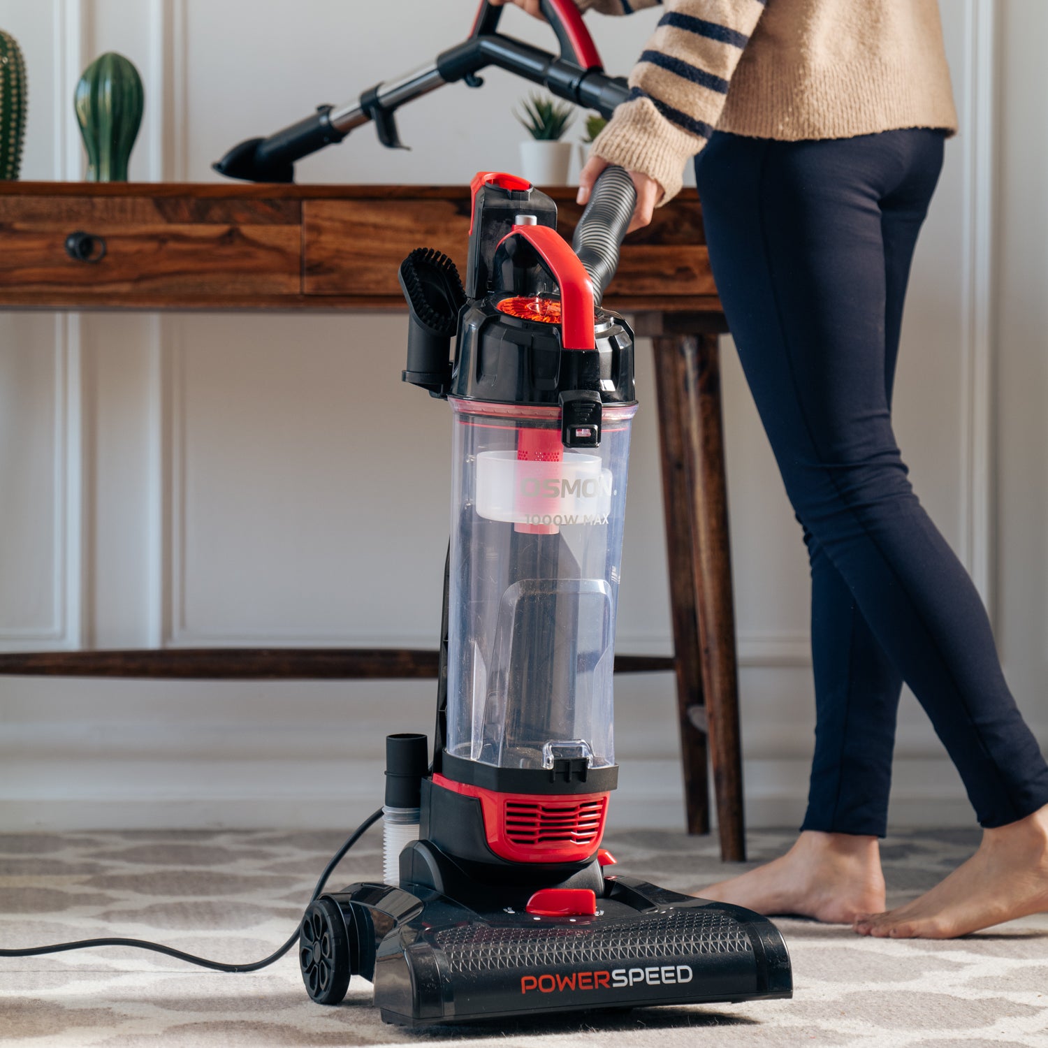 A sleek Red and black vacuum cleaner, the OS 26UBL, stands tall against a backdrop of a clean and tidy living room.