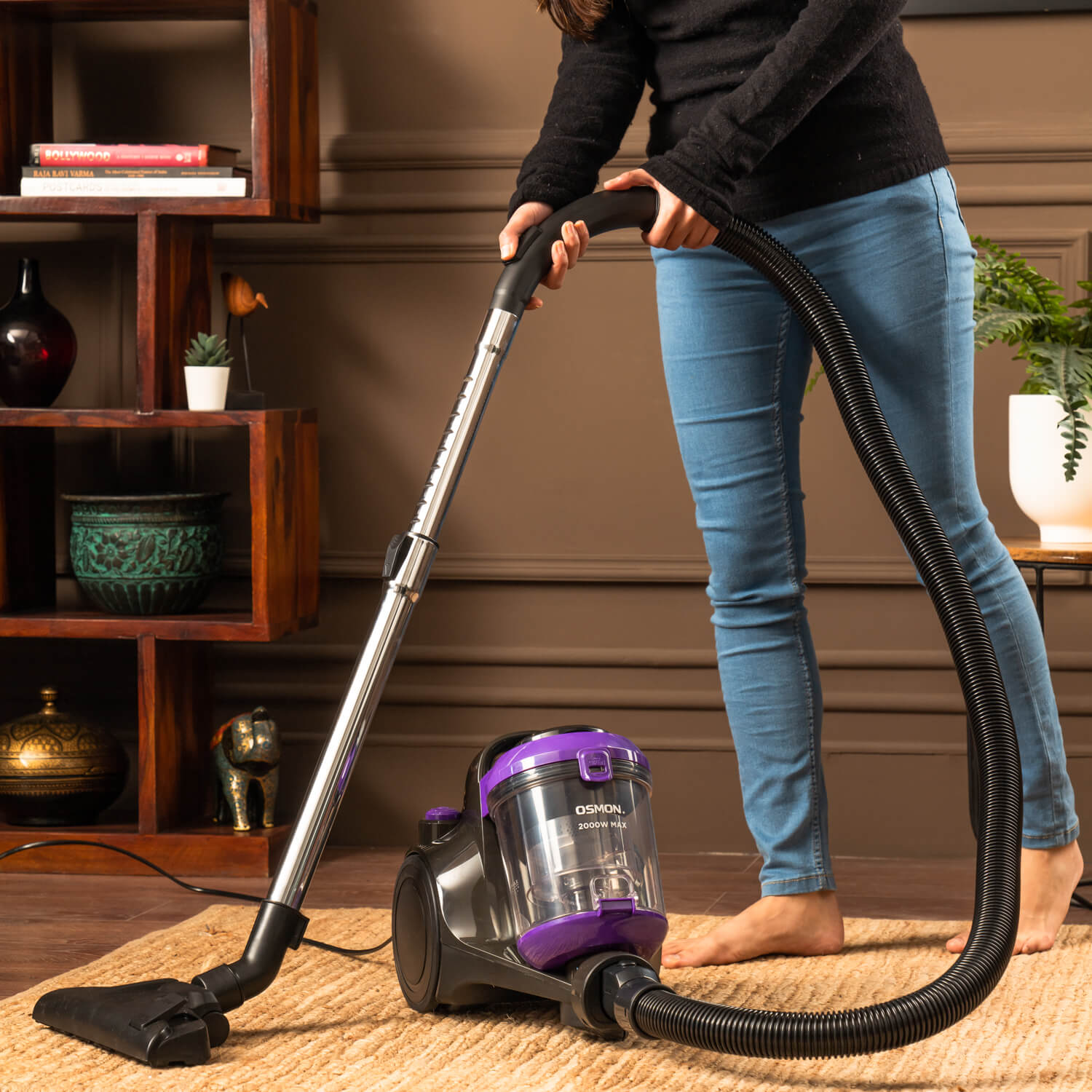 Woman using Osman Purple and black 2000 BL Vacuum cleaner to clean Carpet